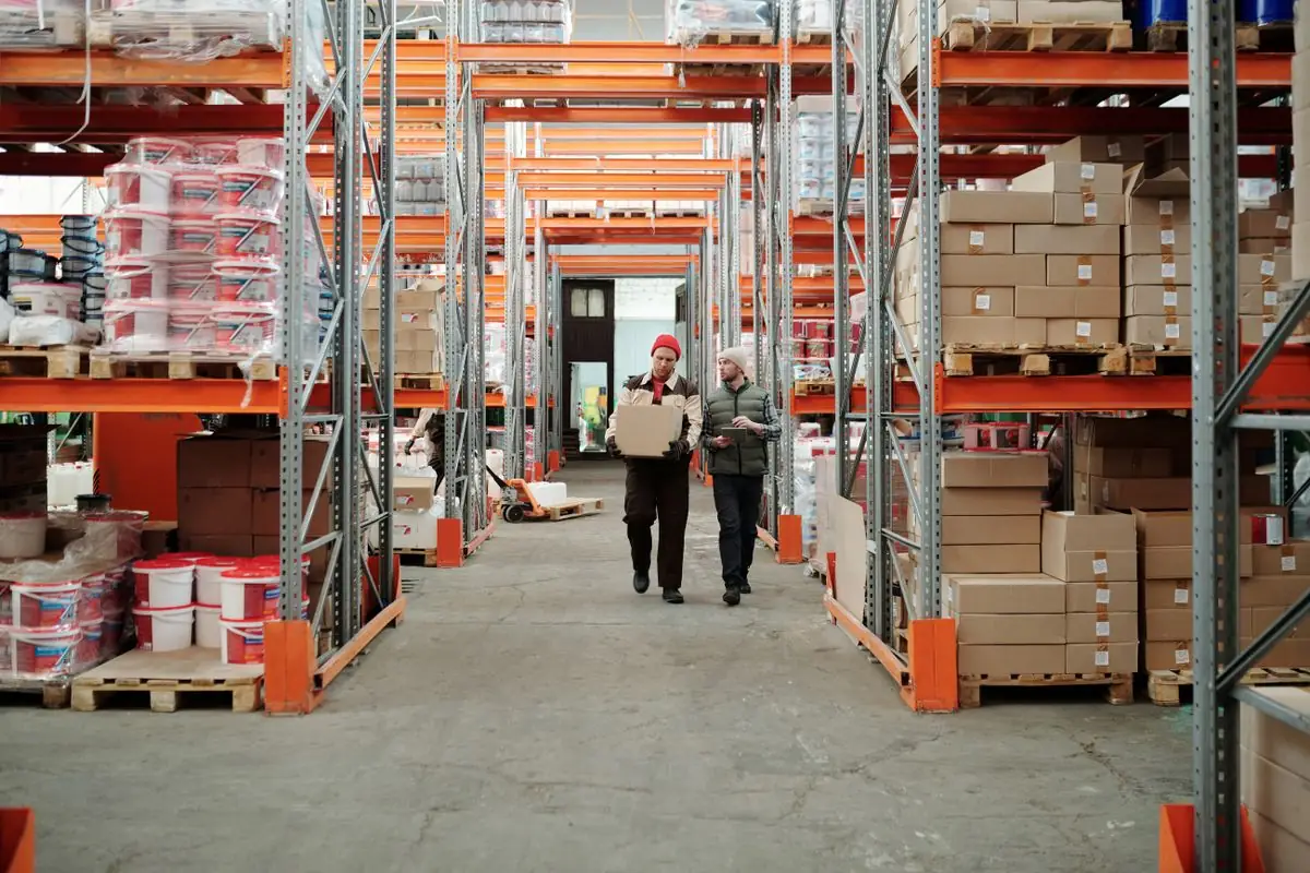 Almacén logístico con estanterías de cajas y palés de mercancía